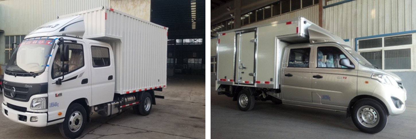 Two white trucks with enclosed cargo boxes extending above the cab